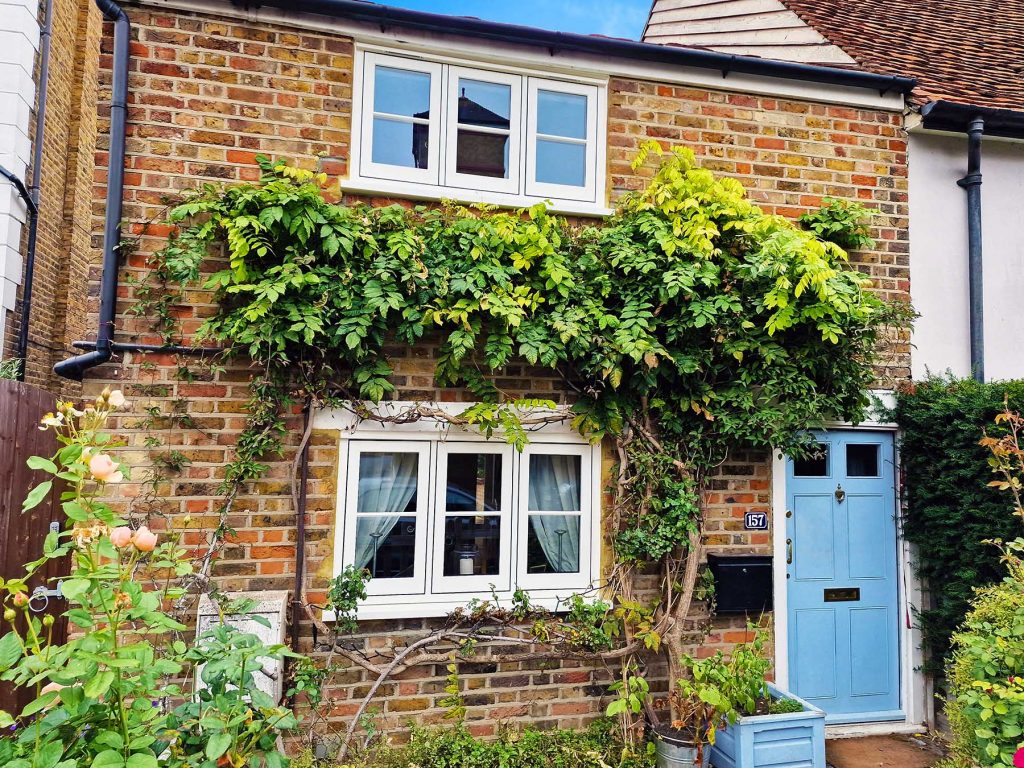 Exterior shot of brick cottage with cream flush sash windows